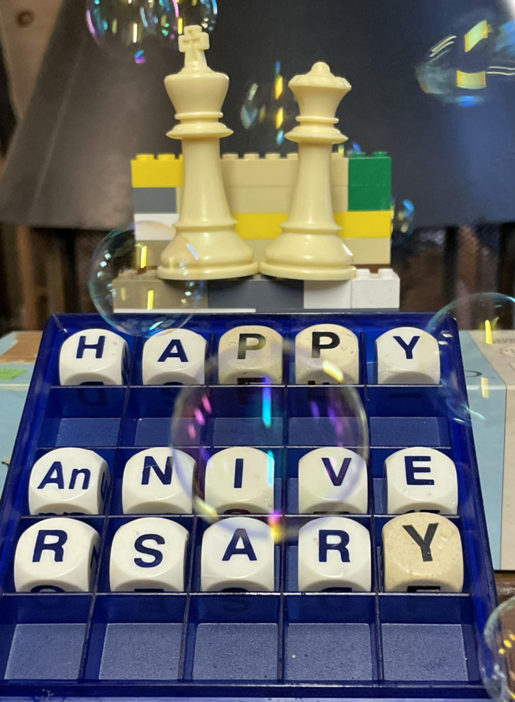 photo of King and Queen Chess pieces and a Boogle Board with the words Happy Anniversary spelled out.