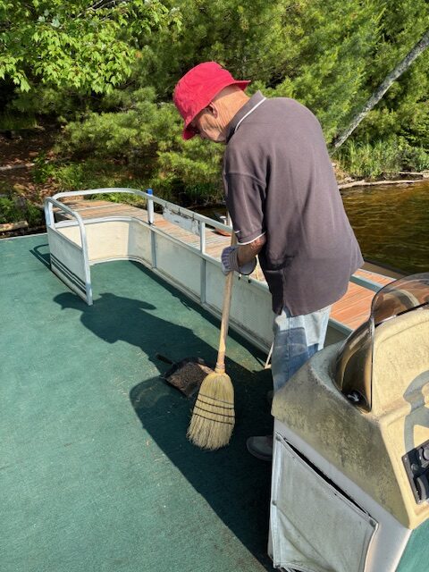 man sweeping barge boat
