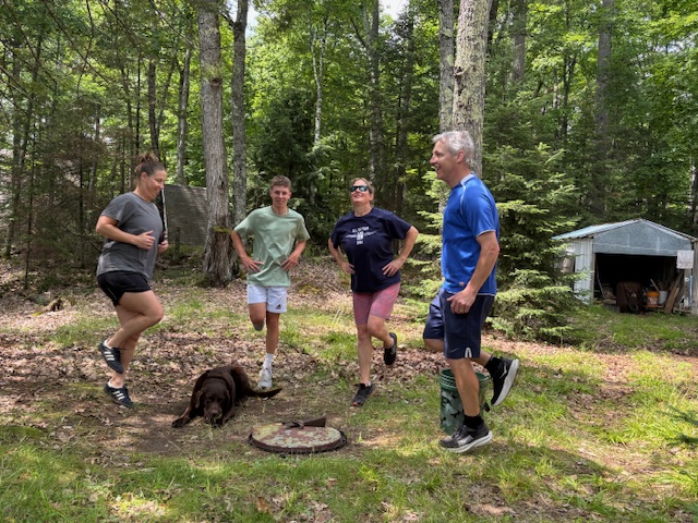 photo of four people doing exercise in front of fire pit and Rey.