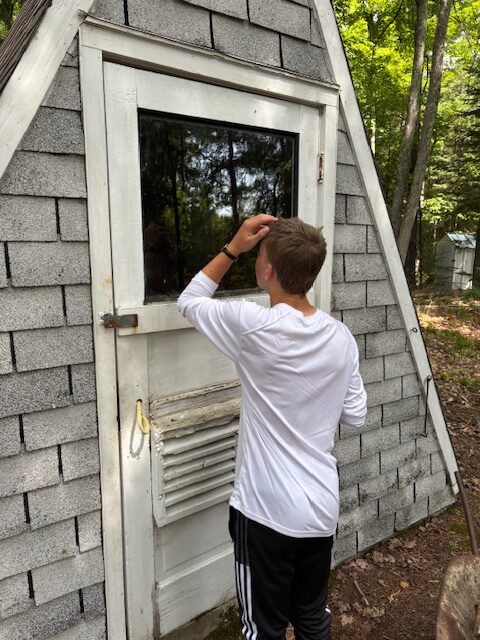 boy looking at himself in a door window pane