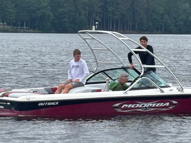 three men on a speedboat waiting to be rescued