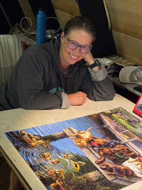 woman sitting in front of a completed puzzle