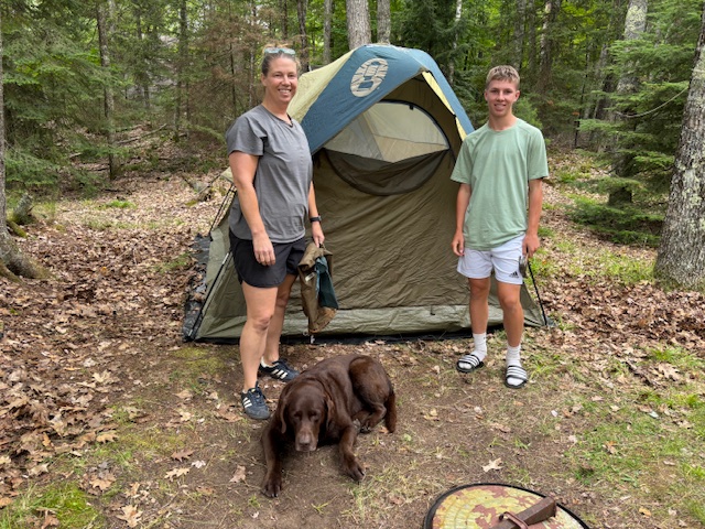 photo of two people in front of tent with Rey.