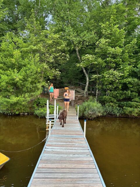 two women and a dog about to take a swim