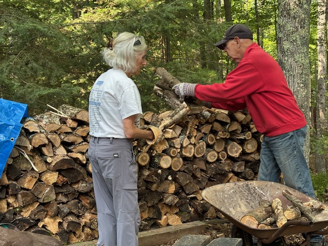 man and woman stacking firewood