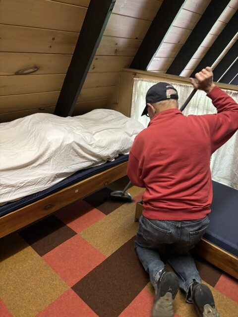 man cleaning under bed